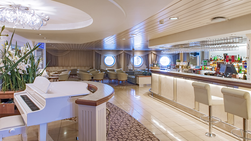 Pianobaren, Baltic Queen. Pianobaren ombord på Baltic Queen, piano, bar med barstola och lounge med sittplatser.